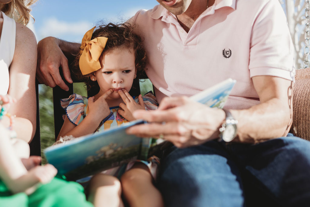 lifestyle family portrait girl reading book with dad parker city