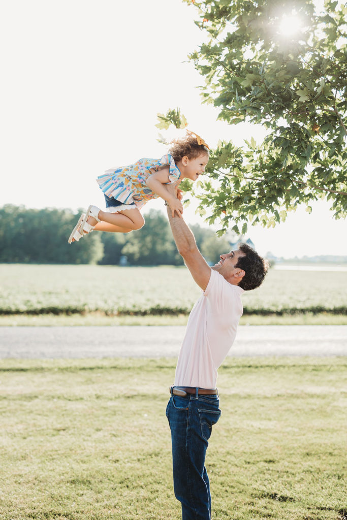 lifestyle family photography dad throws daughter in air noblesville