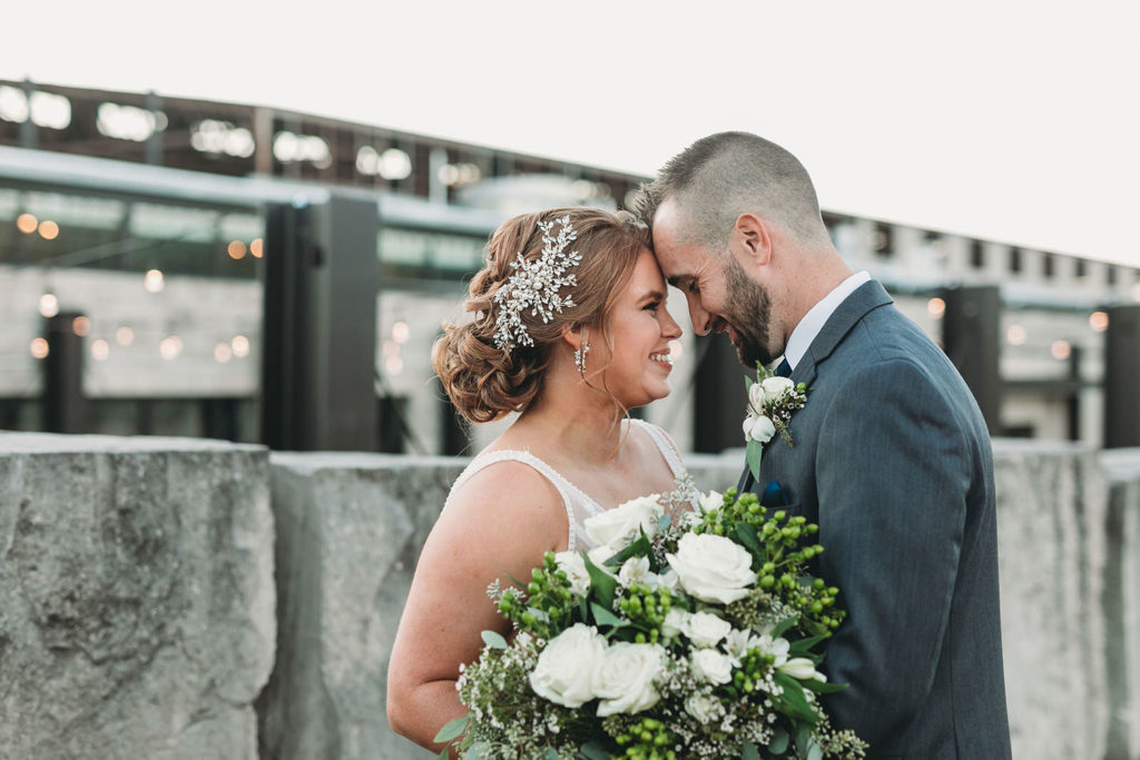 bride and groom touch foreheads in front of large stone blocks at a woolery mill wedding