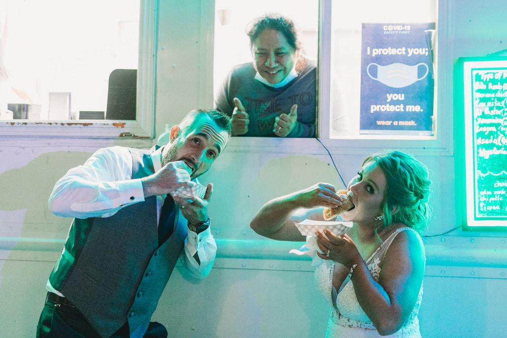 bride and groom in green neon eating tacos next to pili's party taco truck at a woolery mill wedding