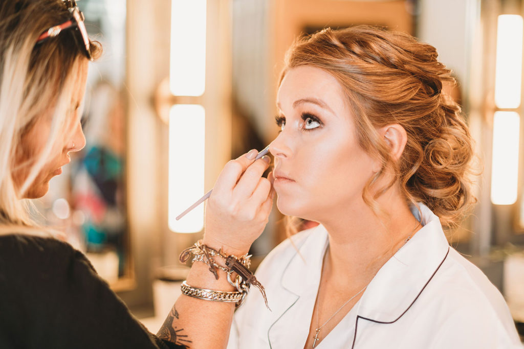 bride getting makeup on at a bloomington wedding