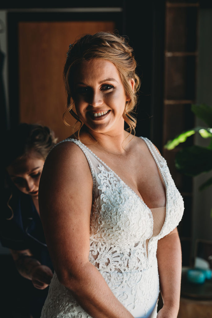 bride smiles in window light at a bloomington wedding