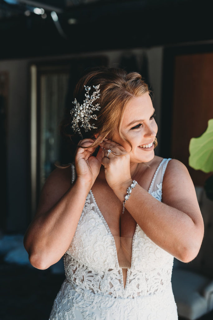 bride puts earrings in at a bloomington wedding