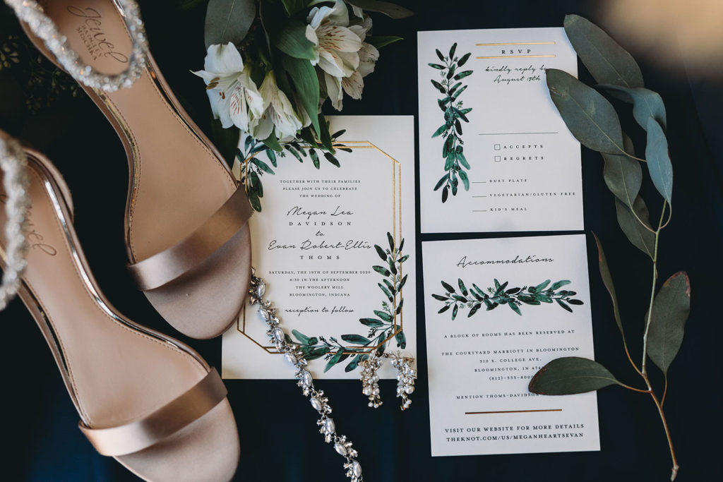 paper invites and shoes and floral on a blue cloth at a bloomington wedding