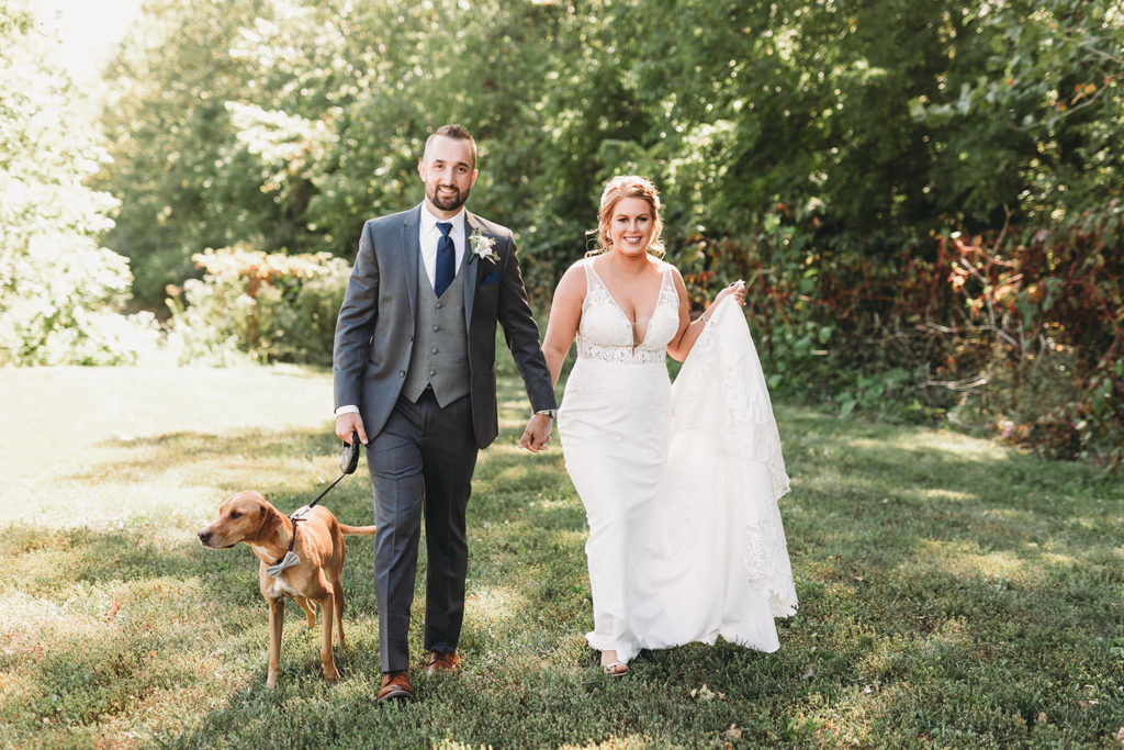bride and groom walk with dog at a woolery mill wedding