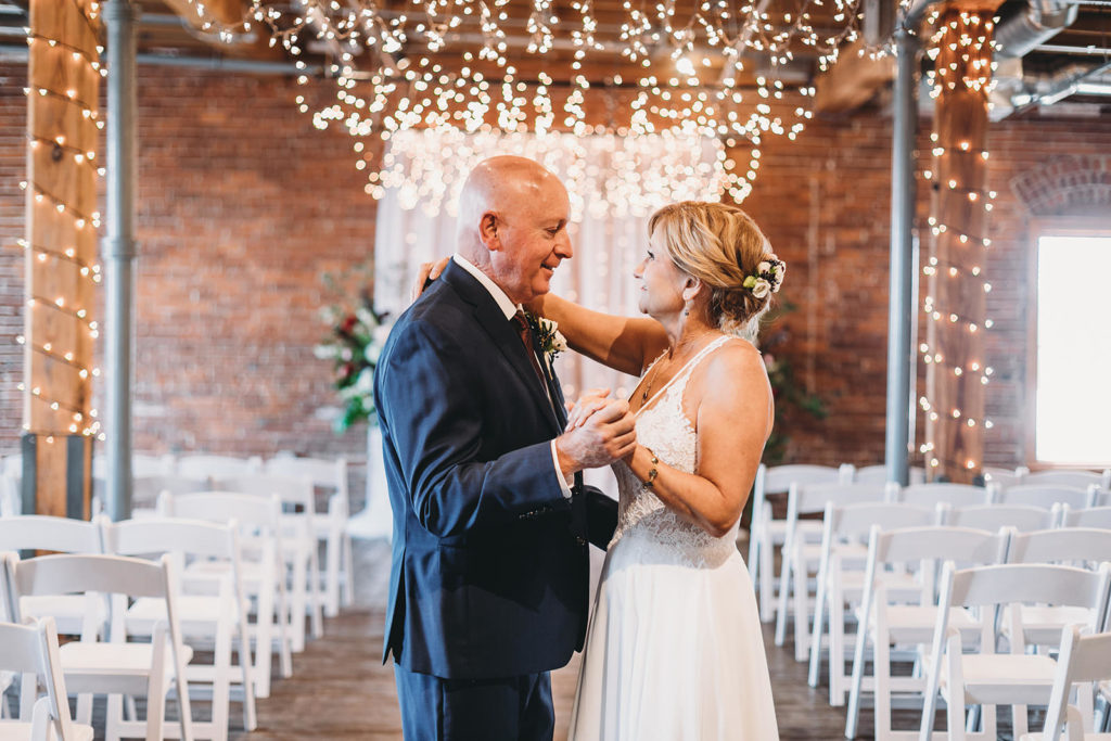 bride and groom dance in front of lights mill top wedding noblesville