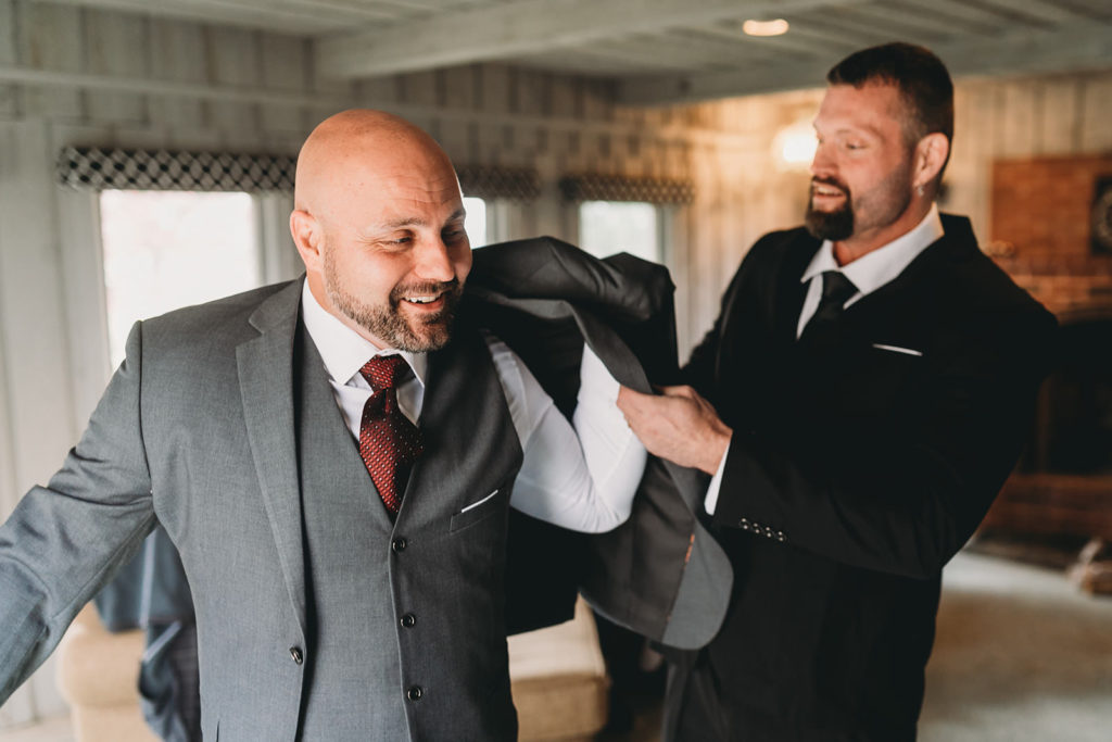 groom helped into jacket at a Franklin Barn Wedding