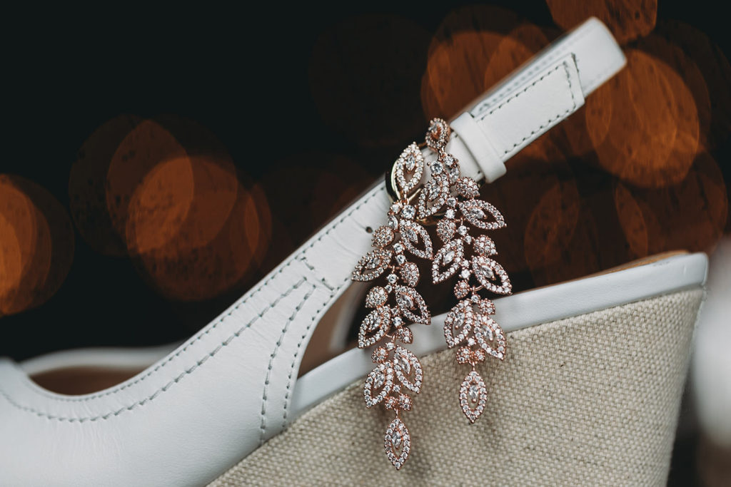 earrings hanging off a shoe with plenty of bokeh in the background at a Franklin Barn Wedding