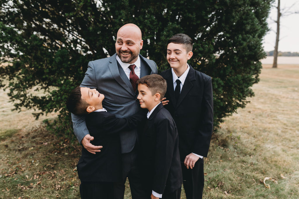 boys hug their stepdad before his wedding ceremony at a Franklin Barn Wedding