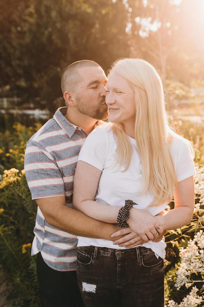 man kisses woman at sunset during Lincoln Park engagement photos