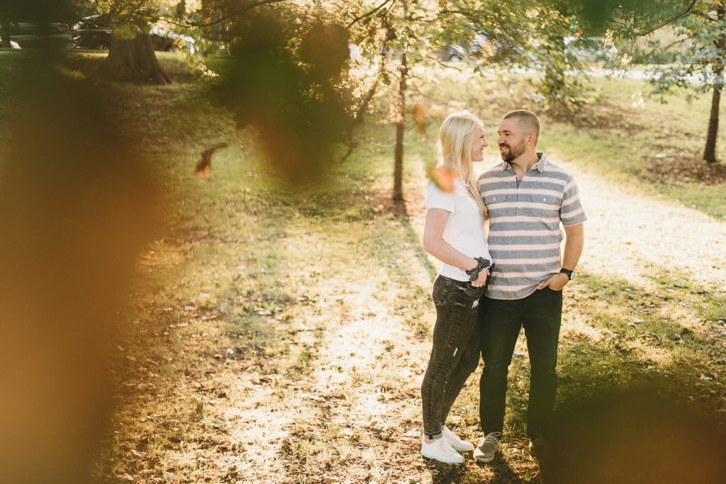 couple hugs while surrounded by leaves during Lincoln Park engagement photos