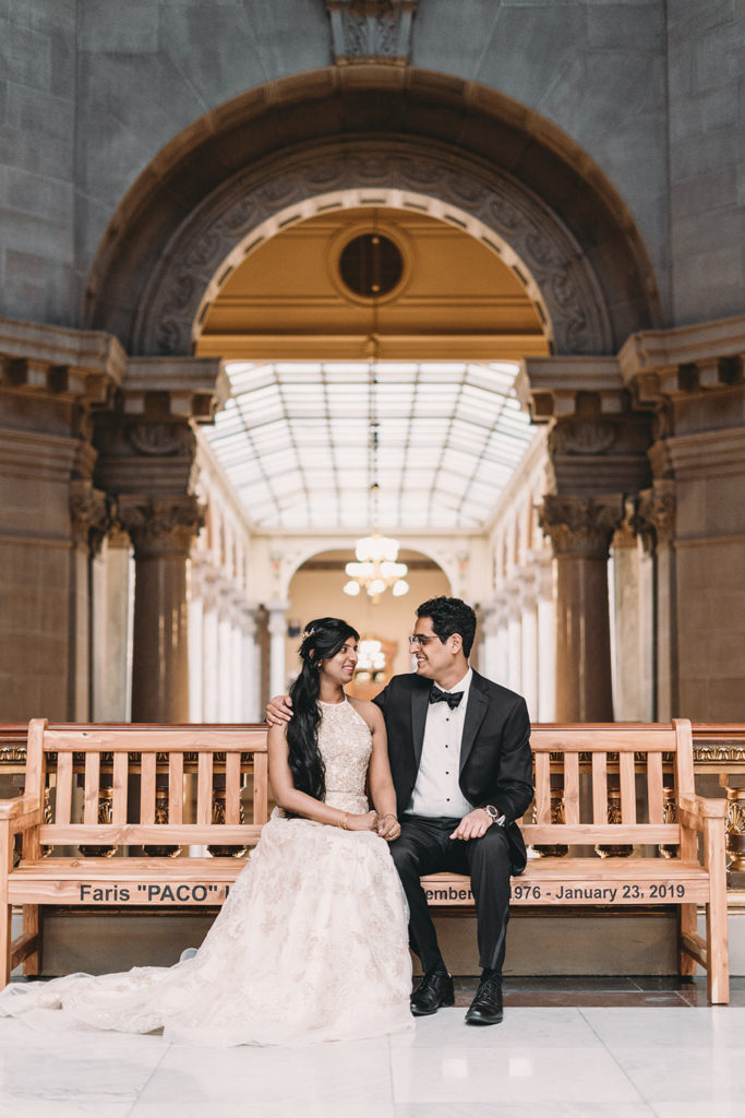 bride and groom sit on bench at their Indiana Statehouse Elopement