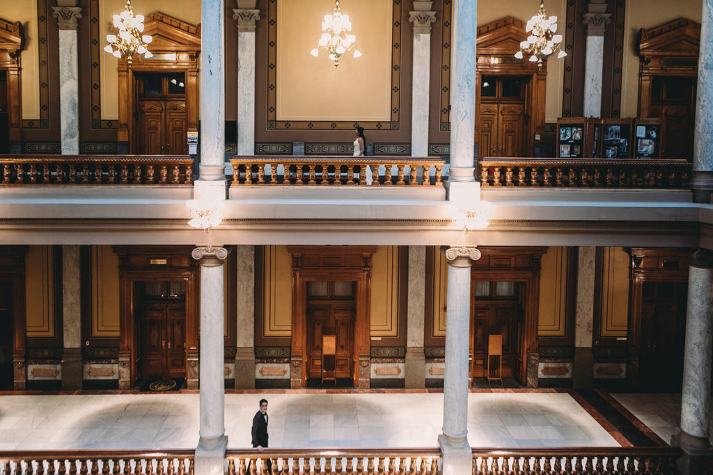 bride and groom walk past each other on different floors during their Indiana Statehouse Elopement