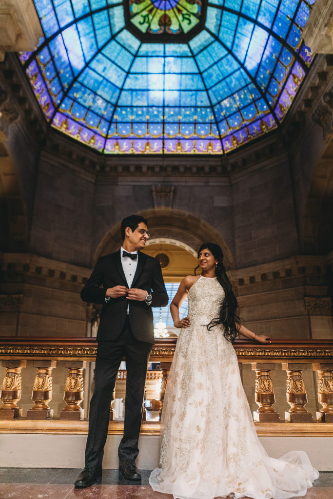 bride and groom standing in front of stained glass dome during their Indiana Statehouse Elopement