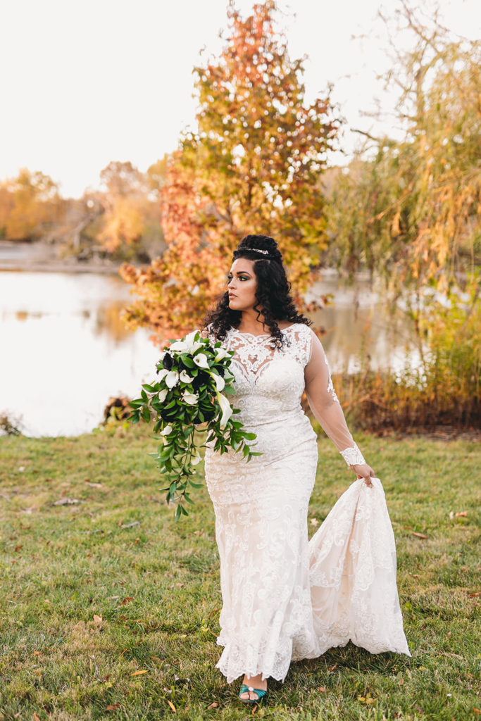 bride holding dress outside in fall before her ceruti wedding