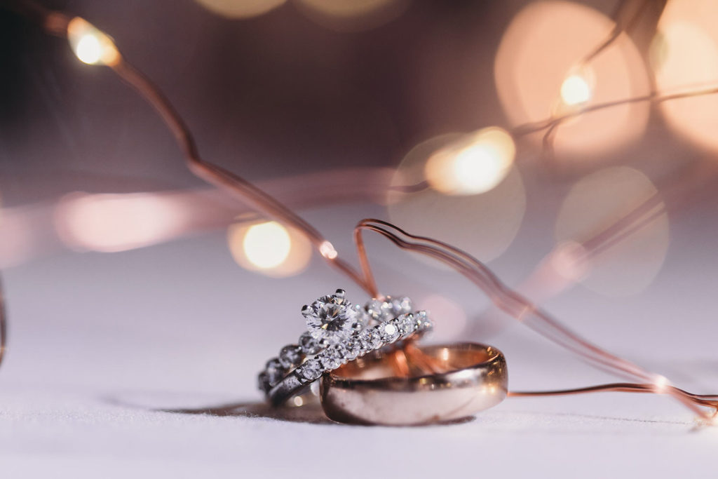 wedding bands and engagement rings surrounded by fairy lights at bluffs wedding