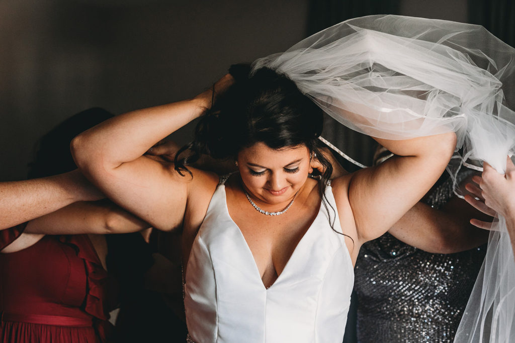 bride puts in veil before bluffs wedding