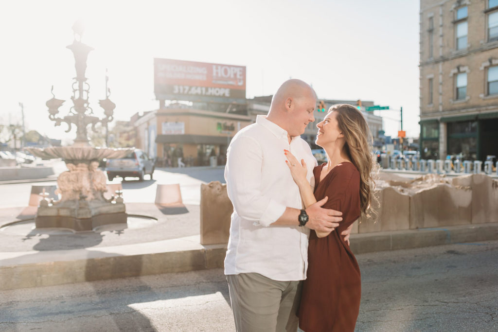 man and woman hug in front of fountain during their Fountain Square Engagement Photos