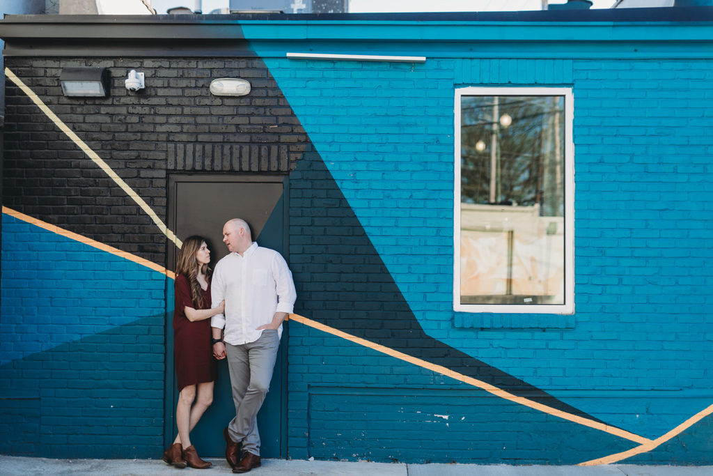 couple in door frame and framed by graffiti art during their Fountain Square Engagement Photos