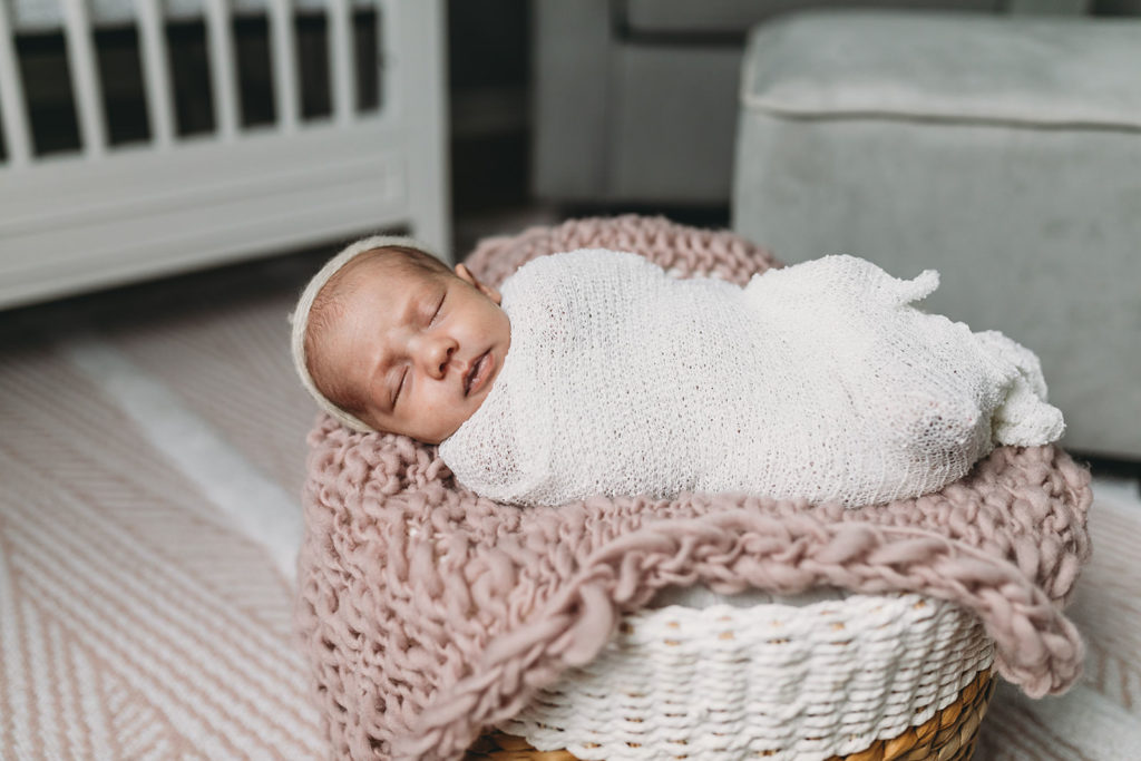 baby in basket with pink knitted blanket captured by their Indy Newborn Photographer