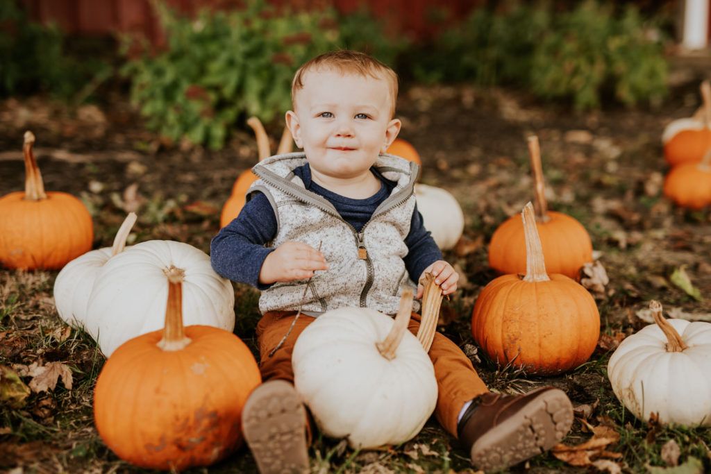 baby surrounded by pumkins during their Russell Farms Family Photos