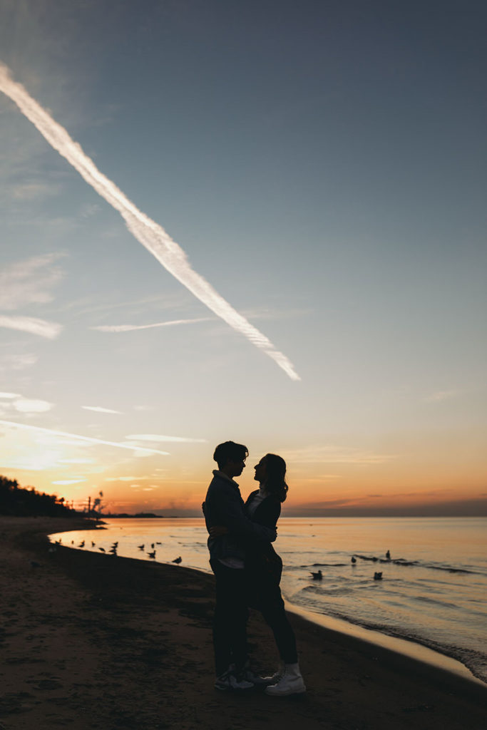 silhouette of young couple looking into each other's eyes during their Indiana Dunes engagement photos