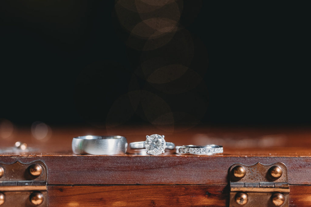 three rings, two wedding bands and one engagement ring, in a row on a table during a traders point creamery elopement