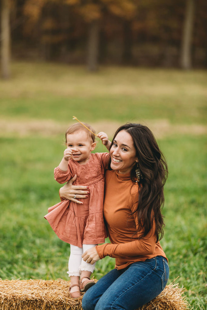 woman in orange sweater holds baby during this Central Indiana Family Photography session