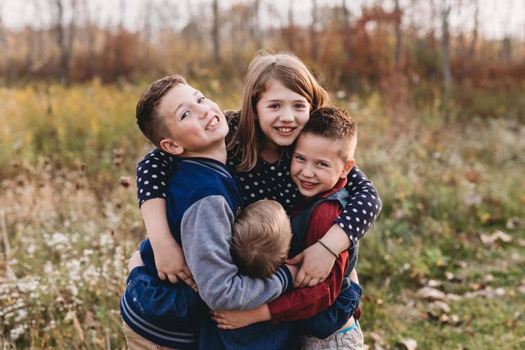 four kids hug in these Carmel Fall Family Photos