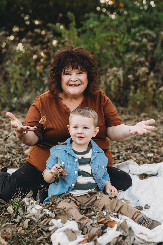 leaves fall around grandma and her grandson during their Strawtown Koteewi Family Photos