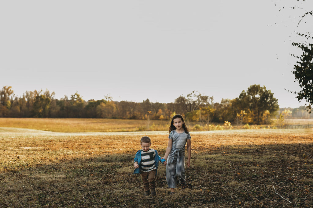 small boy and girl walk across a field during their Strawtown Koteewi Family Photos