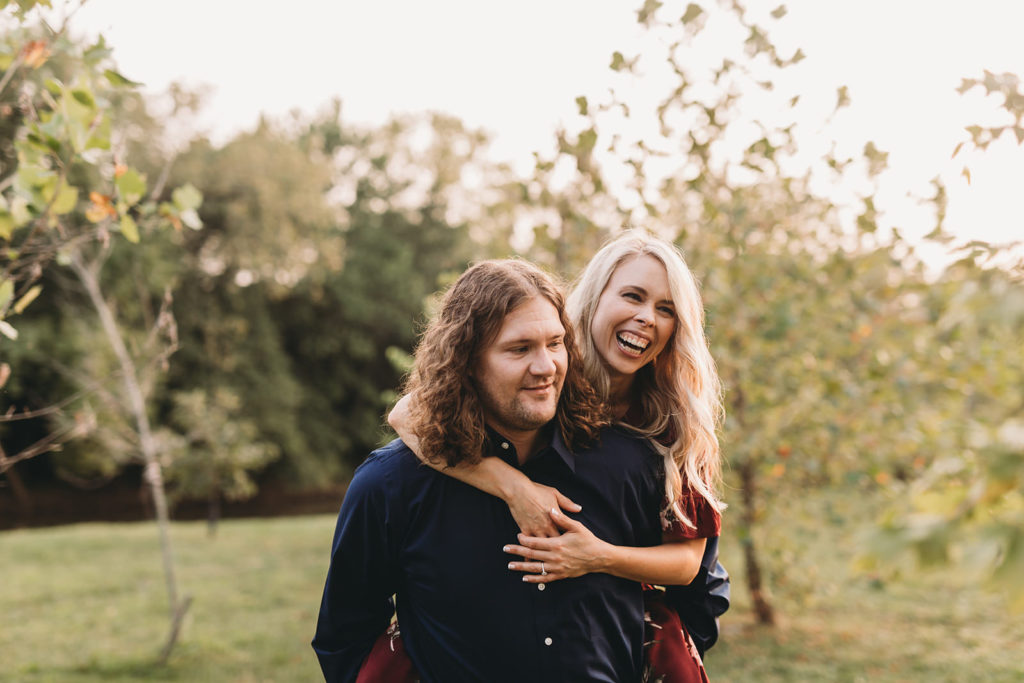 blonde woman and brown haired man laughing during Downtown Muncie Engagement session