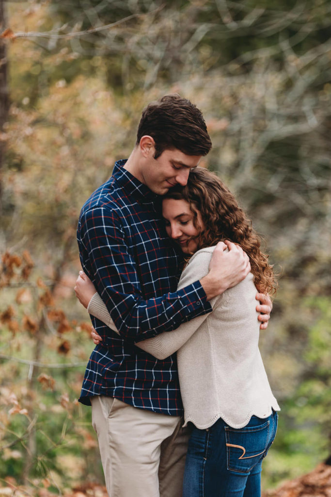 couple hug in field during their Potters Bridge Engagement session