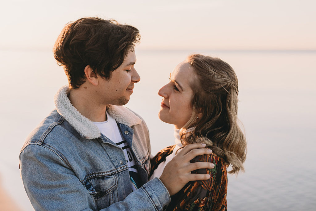 man and woman look lovingly into each other's eyes on the shore of Lake Michigan at an Indiana National Park