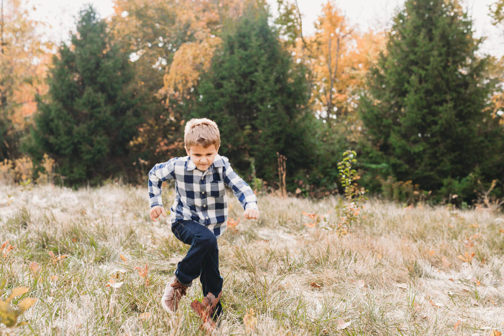boy runs through field captured by a Carmel Family Photographer
