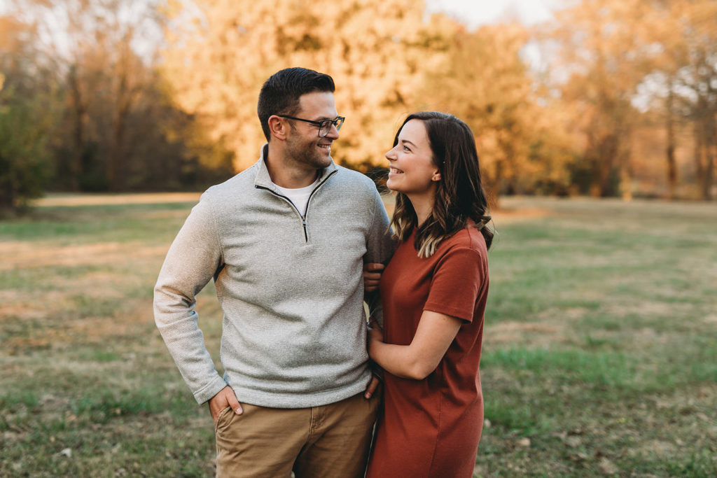 brown haired couple hug in fall during their Strawtown Koteewi Family Photos