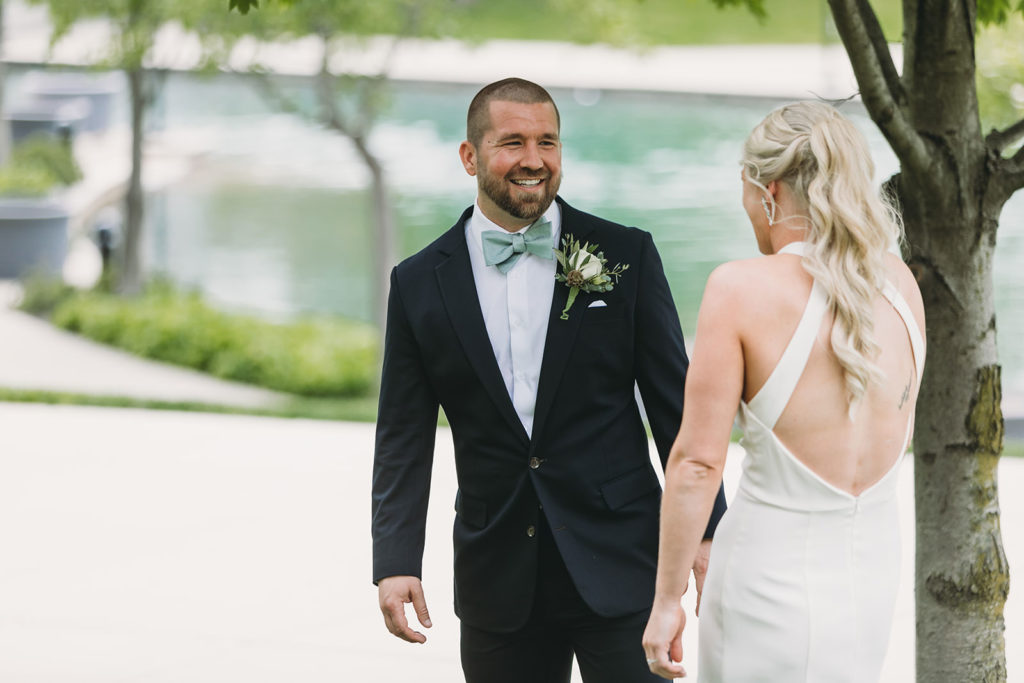groom smiles at bride during first look at their indy canal wedding