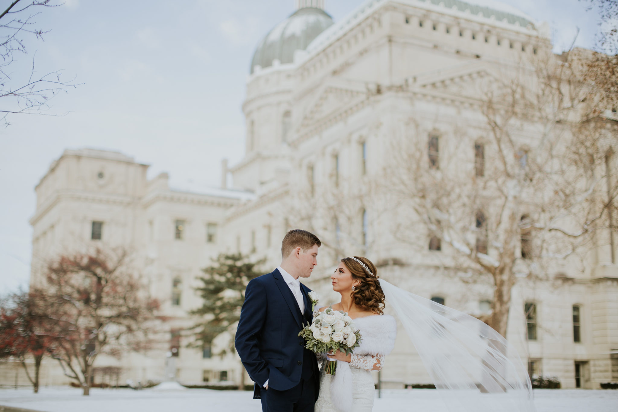 Wedding Photo of Groom and Bride in front of Indiana Statehouse in Winter with Snow on Ground