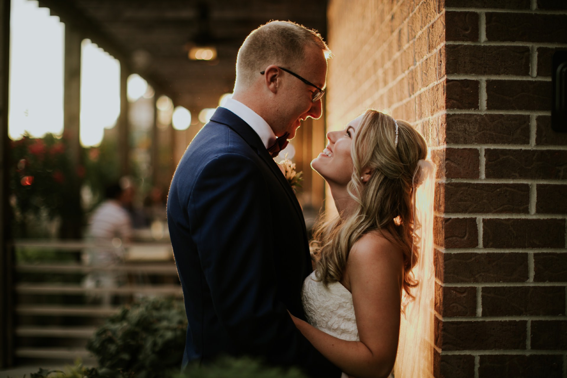 a blonde bride looks up at her bespectacled blonde groom at sunset at their rathskeller wedding