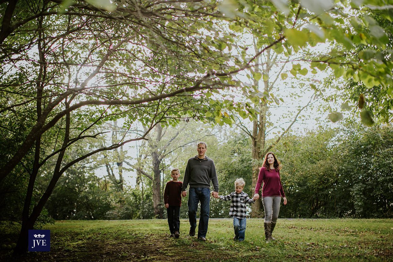 family walks amongst the trees in noblesville family photography session
