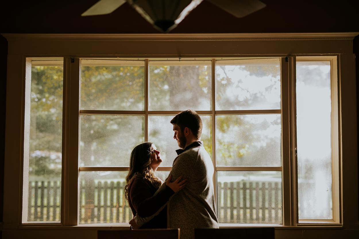silhouette of man and woman in front of window at zyntango farm engagement session