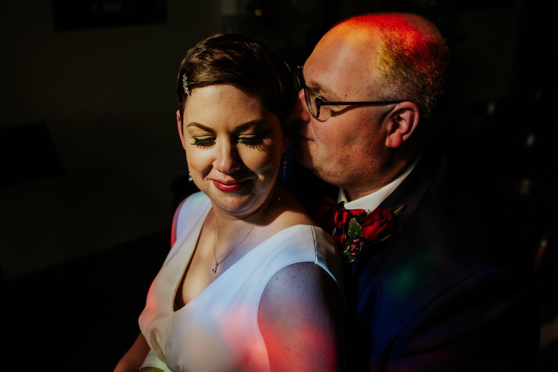 mesh wedding with ashley and chris posed in light filtered through a stained glass window in the indiana statehouse