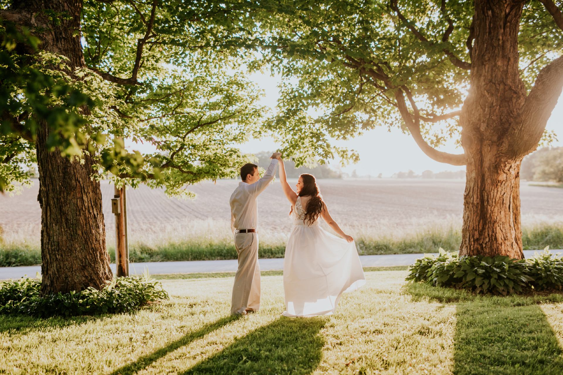 spinning woman holding man's hand at sunset in this indiana country engagement session
