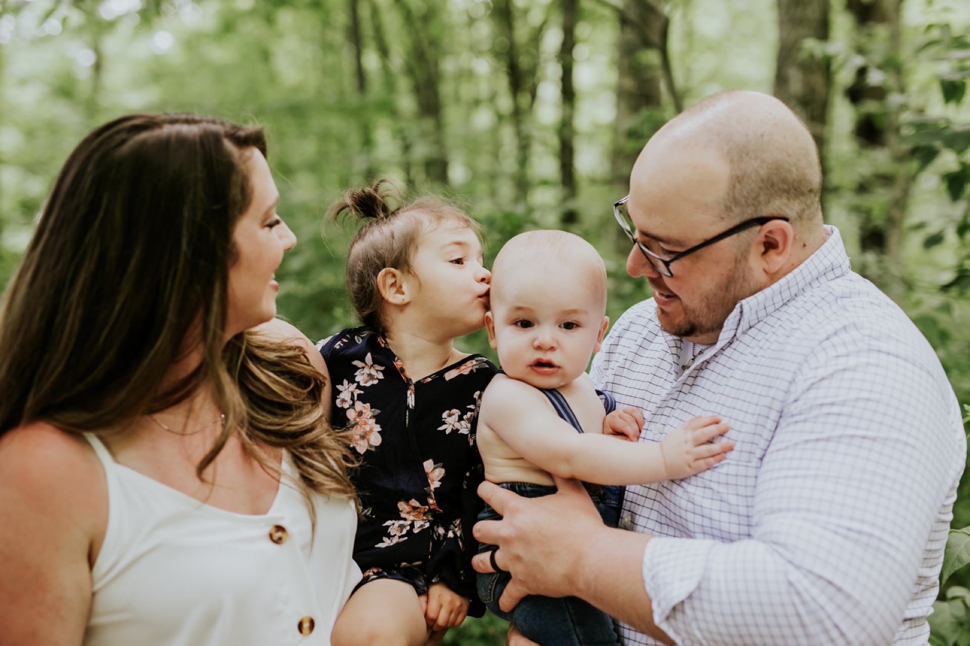 toddler aged girl leans over and kisses baby brother on the head in this Hamilton County Family Photography session