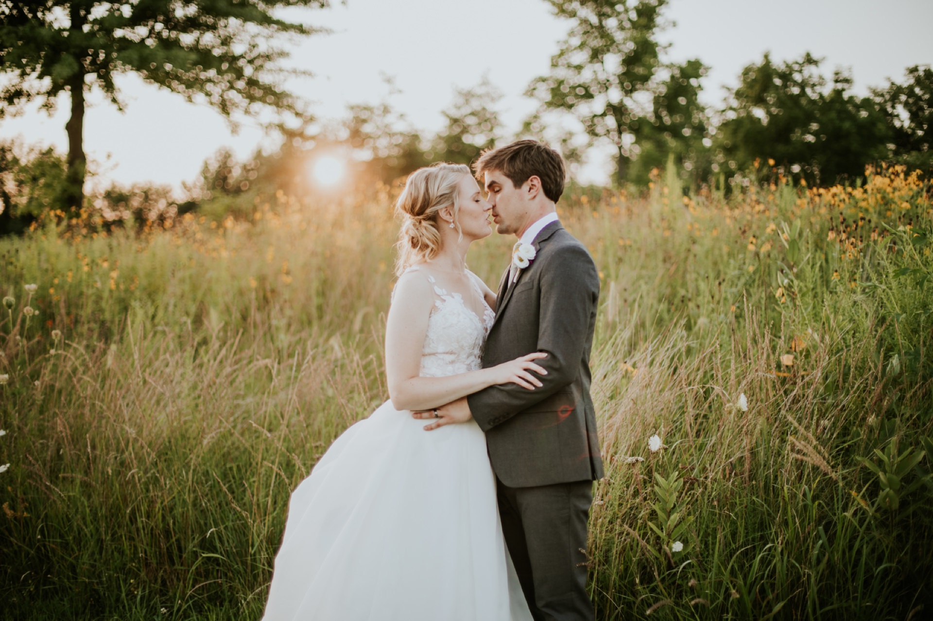 bride and groom kissing at sunset with sun setting over the bride's shoulder for their muncie wedding photography