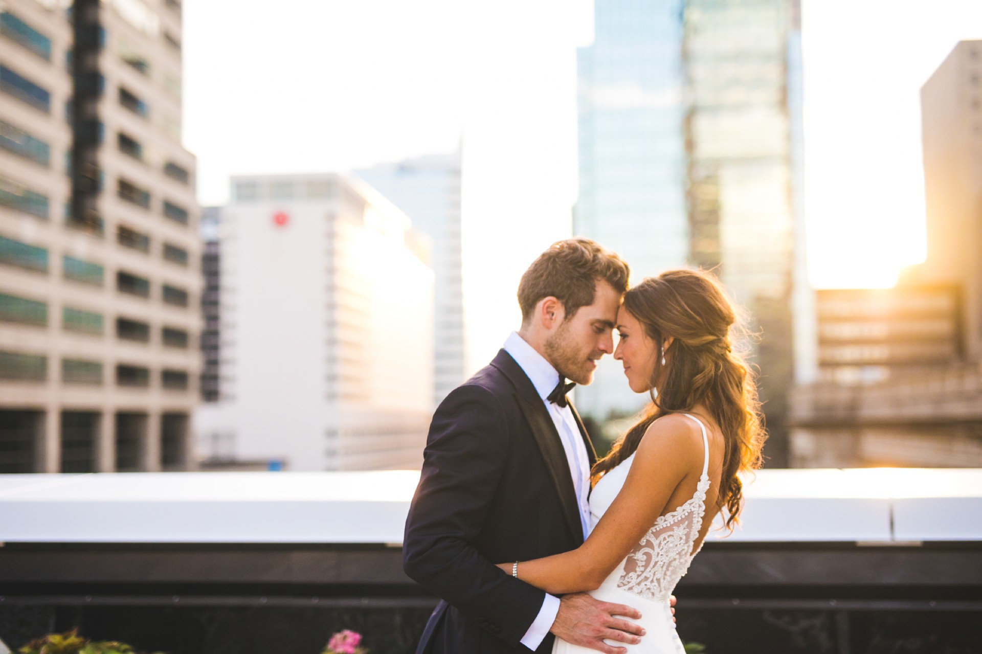 bride and groom hug at sunset on roof of regions tower during indianapolis wedding photography