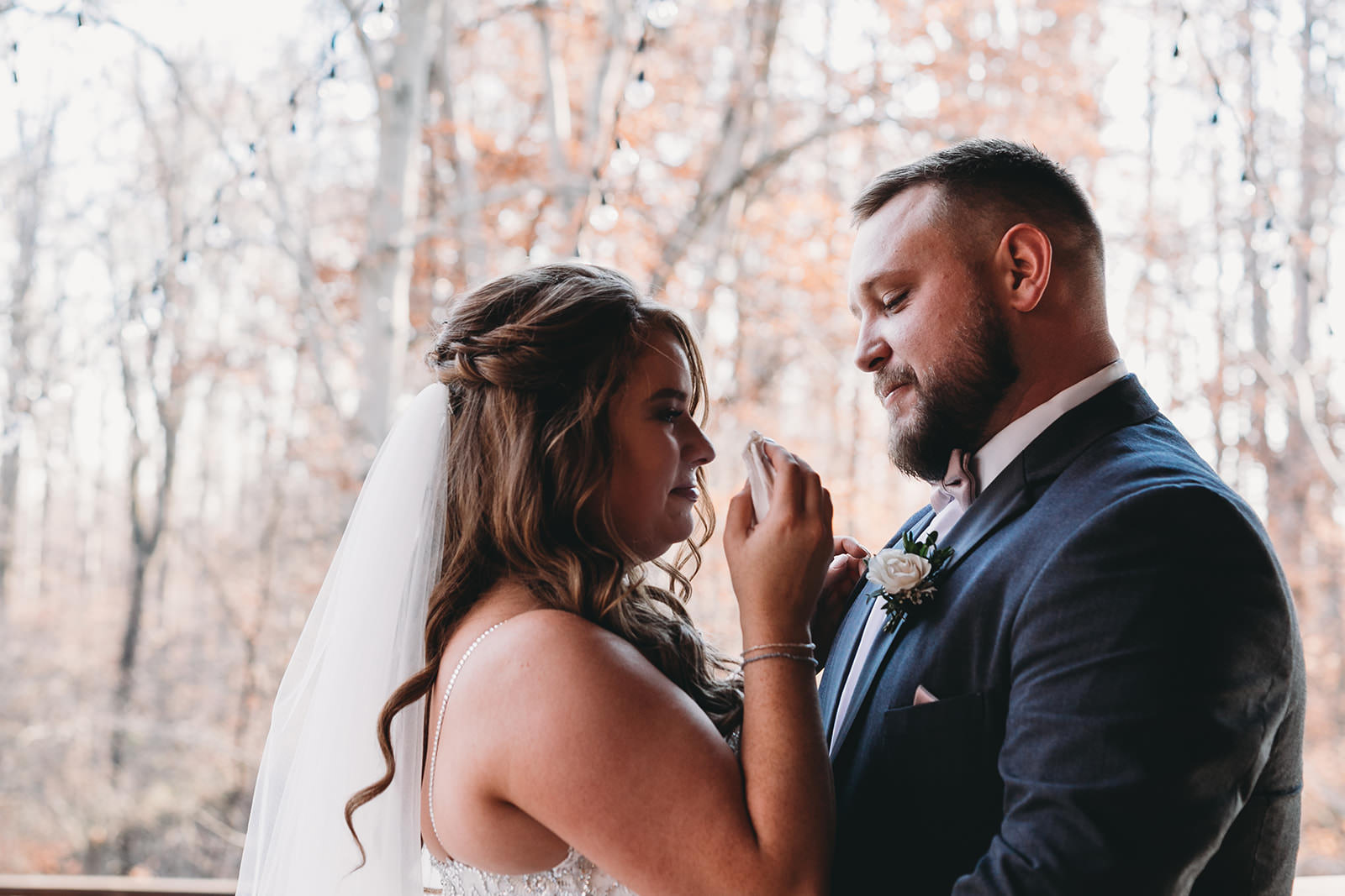 bride cries as she looks at groom in front of woods in fall at their 3 Fat Labs wedding