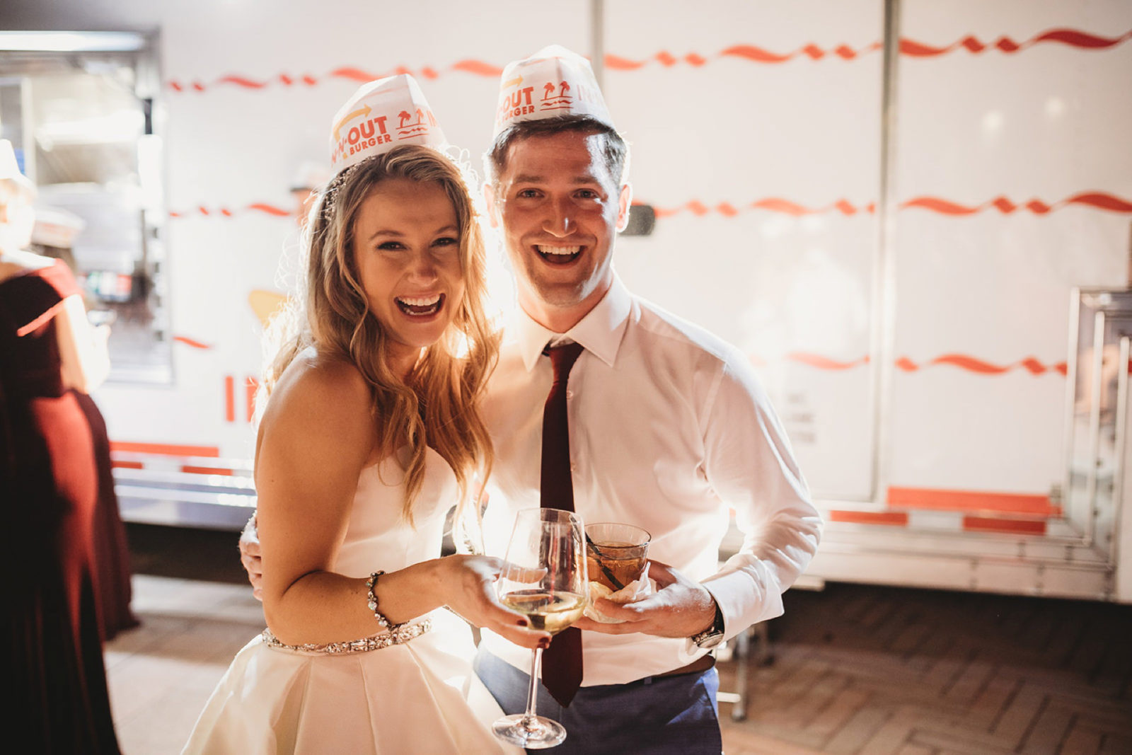 bride and groom in In-N-Out burger hats standing in front of an In-N-Out truck at their wedding at The Resort at Pelican Hill in Newport Beach