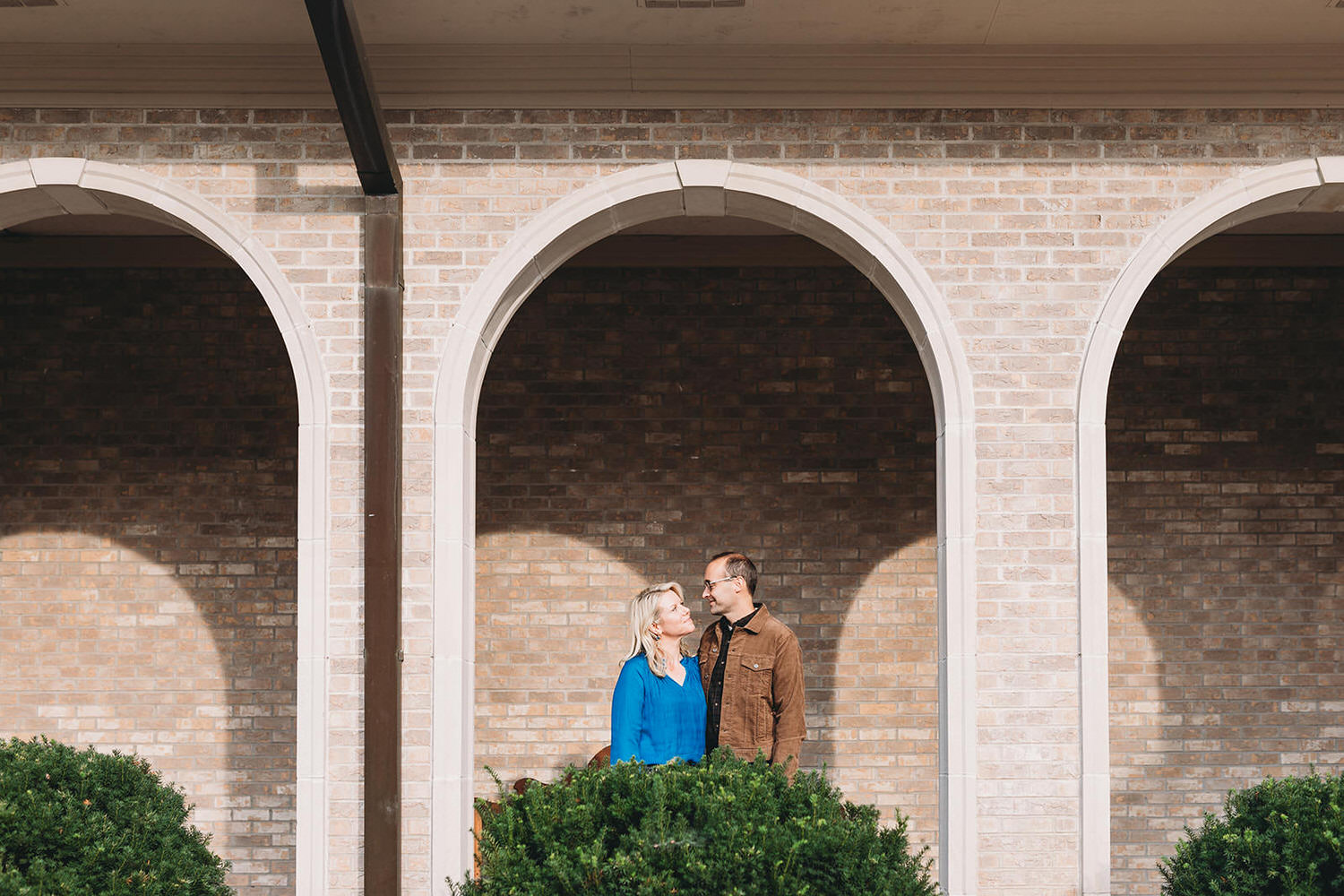 couple under arches at their sand creek engagement session