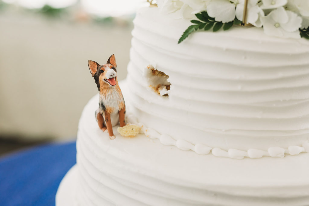 little dog figurine on cake that looks like it took a bite out of the cake at this Charming Regions Tower Wedding